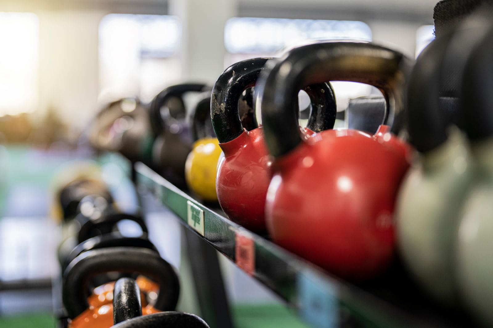 Rows of kettlebells racked on a gym shelf